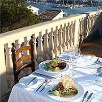 Restaurants in den Golfregion aufgeteilt nach Luxus, Gehoben, Preiswert und mit Meerblick Gedeck und Meer im Hintergrund